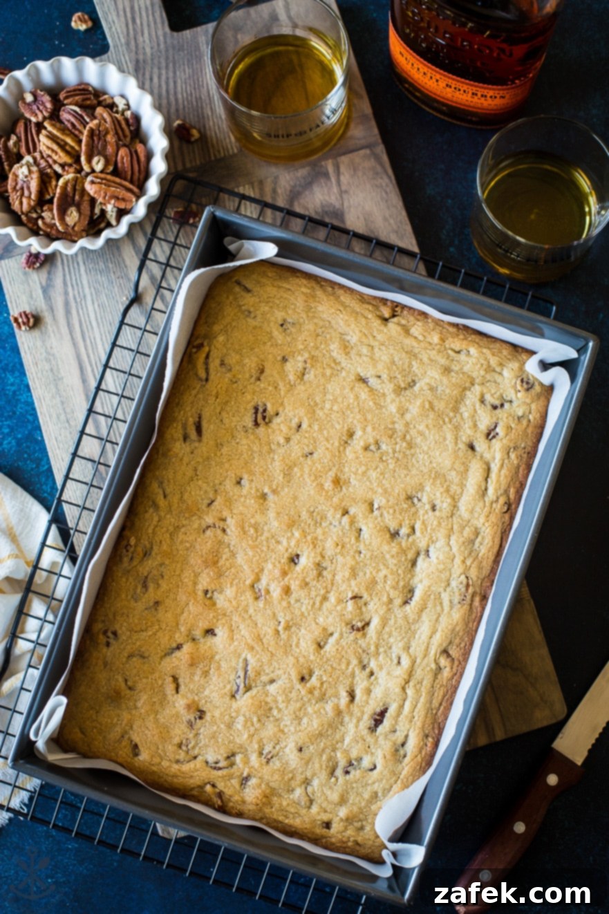 Overhead photo of 9x13 pan of pecan bourbon blondies, showcasing their golden-brown tops and rich texture.