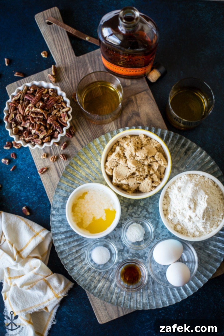 Overhead photo of the key ingredients for pecan bourbon blondies laid out on a rustic wooden board with a silver tray.