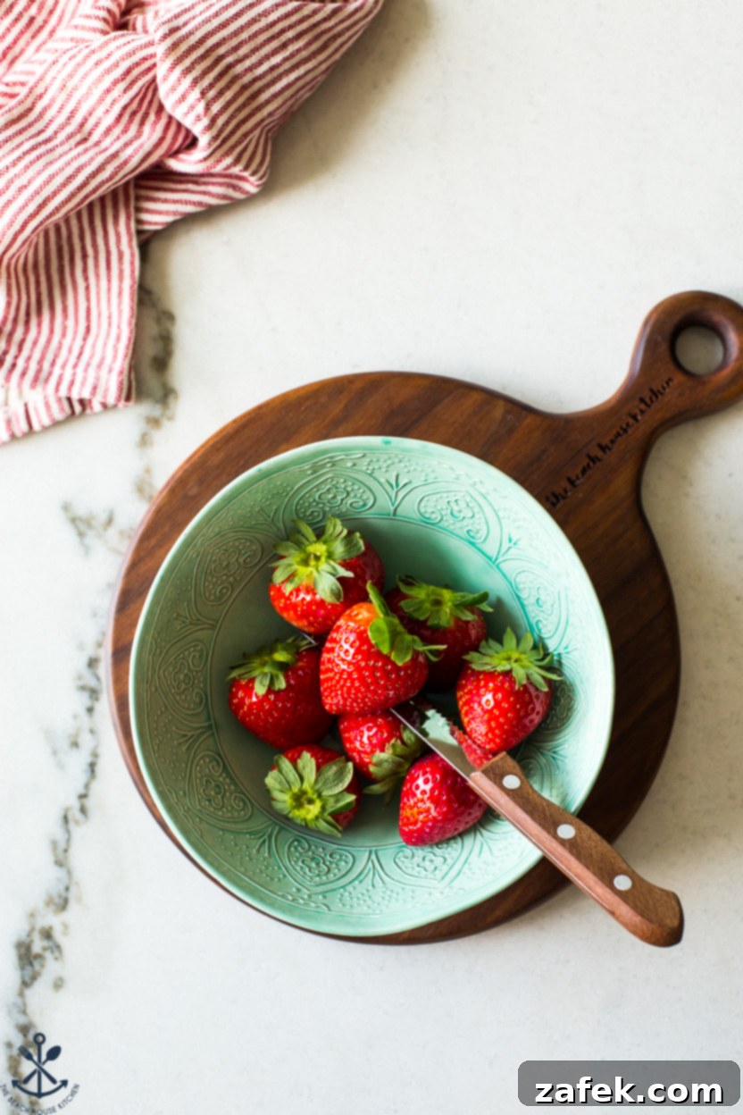 Blushing Strawberry Caramel Tart 3 Overhead photo of a vibrant green bowl filled with freshly picked, ripe strawberries.