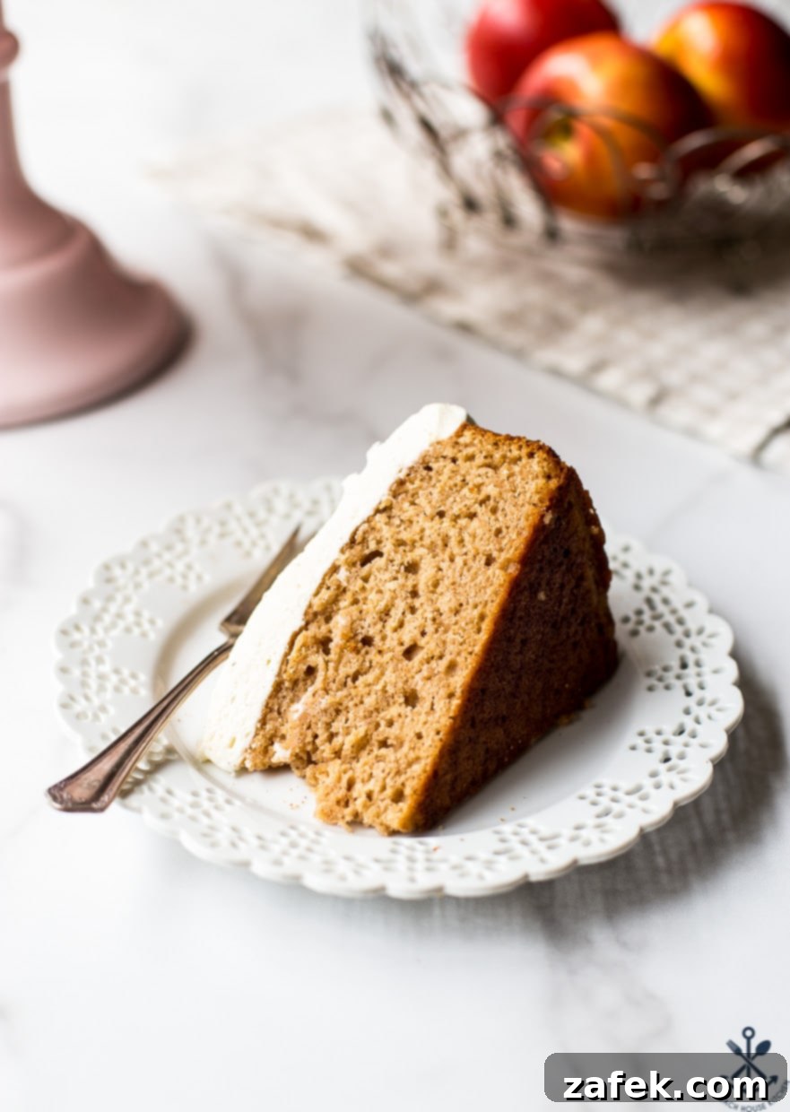 A captivating close-up photo of a single slice of Applesauce Cake with Vanilla Bean Frosting, showcasing its moist crumb and the creamy texture of the frosting, ready to be enjoyed as a delightful treat.