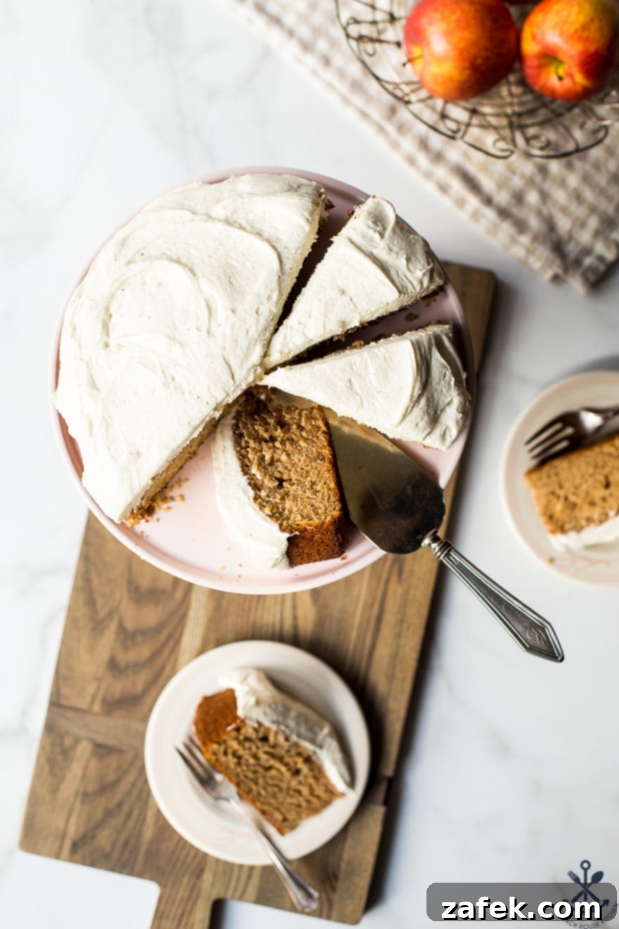 An elegant overhead shot of the complete Applesauce Cake with Vanilla Bean Frosting, beautifully presented on a simple cake stand, ready for slicing and serving guests.