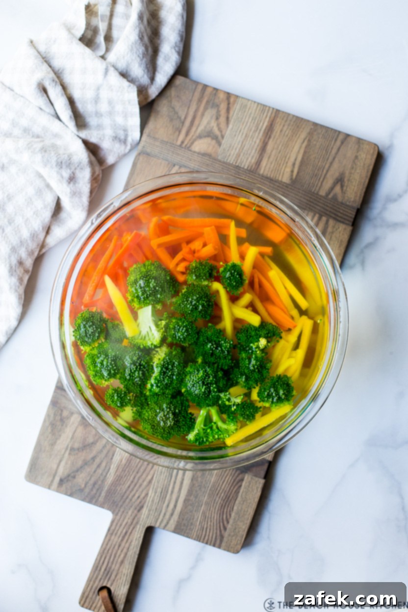 Spring Vegetable Pasta 4 Overhead photo of a bowl of veggies covered in water, demonstrating the blanching step