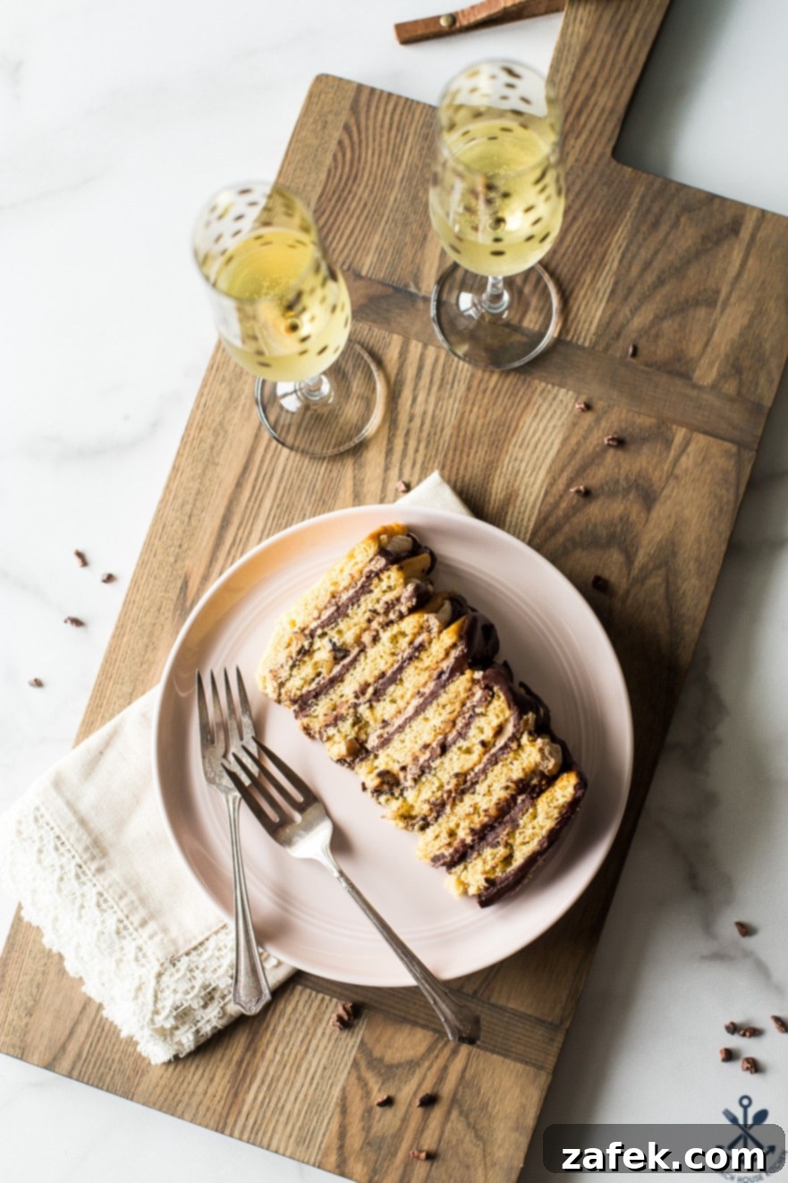 Armenian Honey Cake 4 Overhead shot of a slice of Armenian-style layer cake on a plate, elegantly presented with two glasses of champagne, inviting indulgence