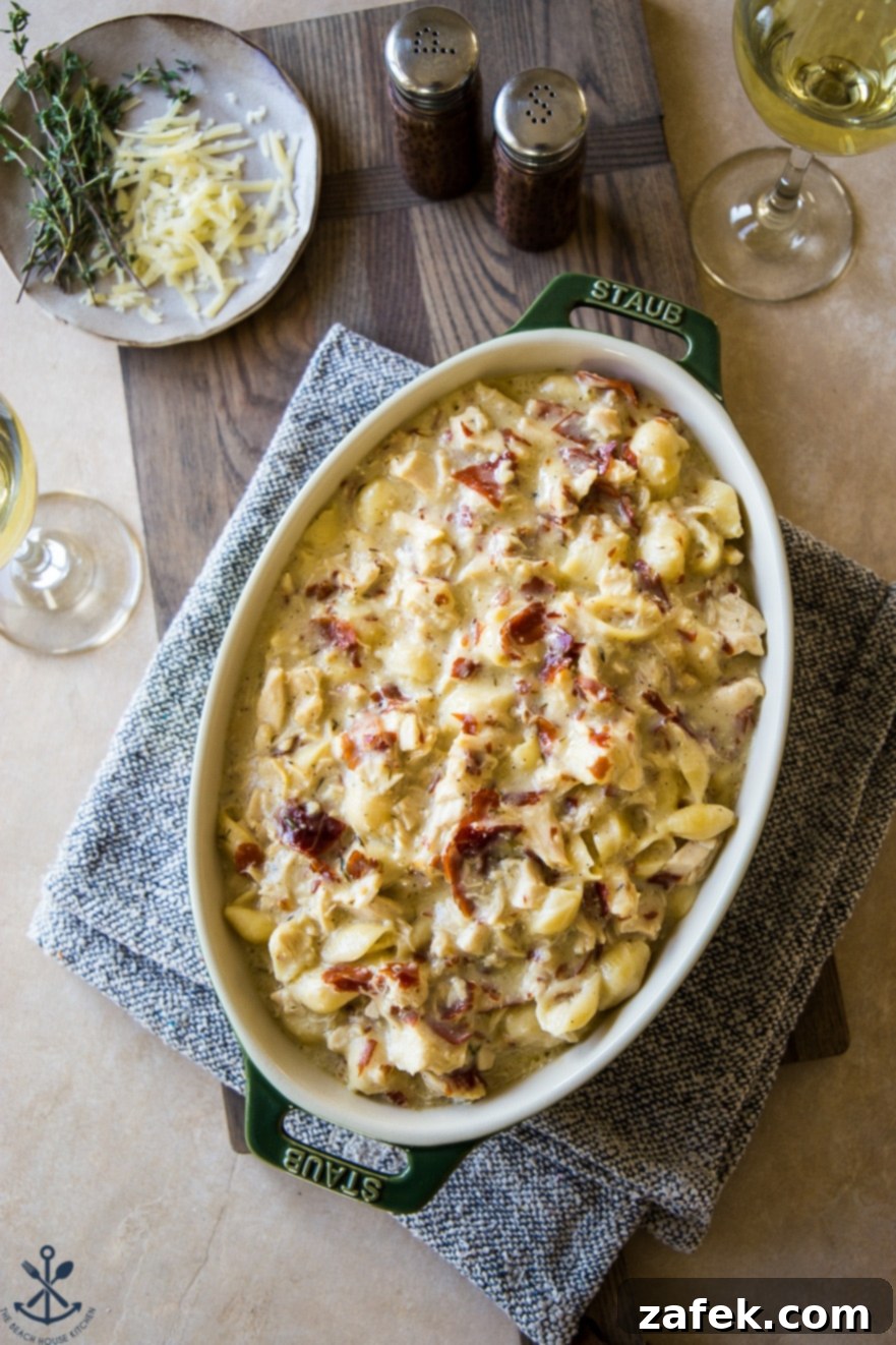 Creamy Cordon Bleu Chicken Pasta Bake 2 Overhead photo of a golden brown chicken cordon bleu pasta bake in a large baking dish, ready to be served, garnished with fresh herbs.