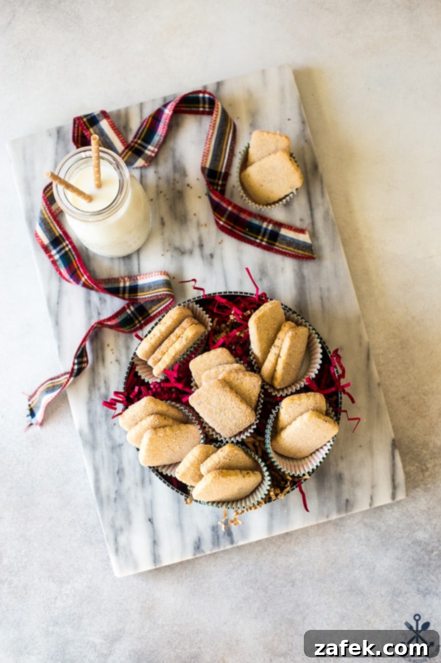 An overhead view of a festive round cookie tin brimming with an abundance of golden-brown Biscochitos, each dusted with glistening cinnamon sugar, inviting a delightful holiday treat.