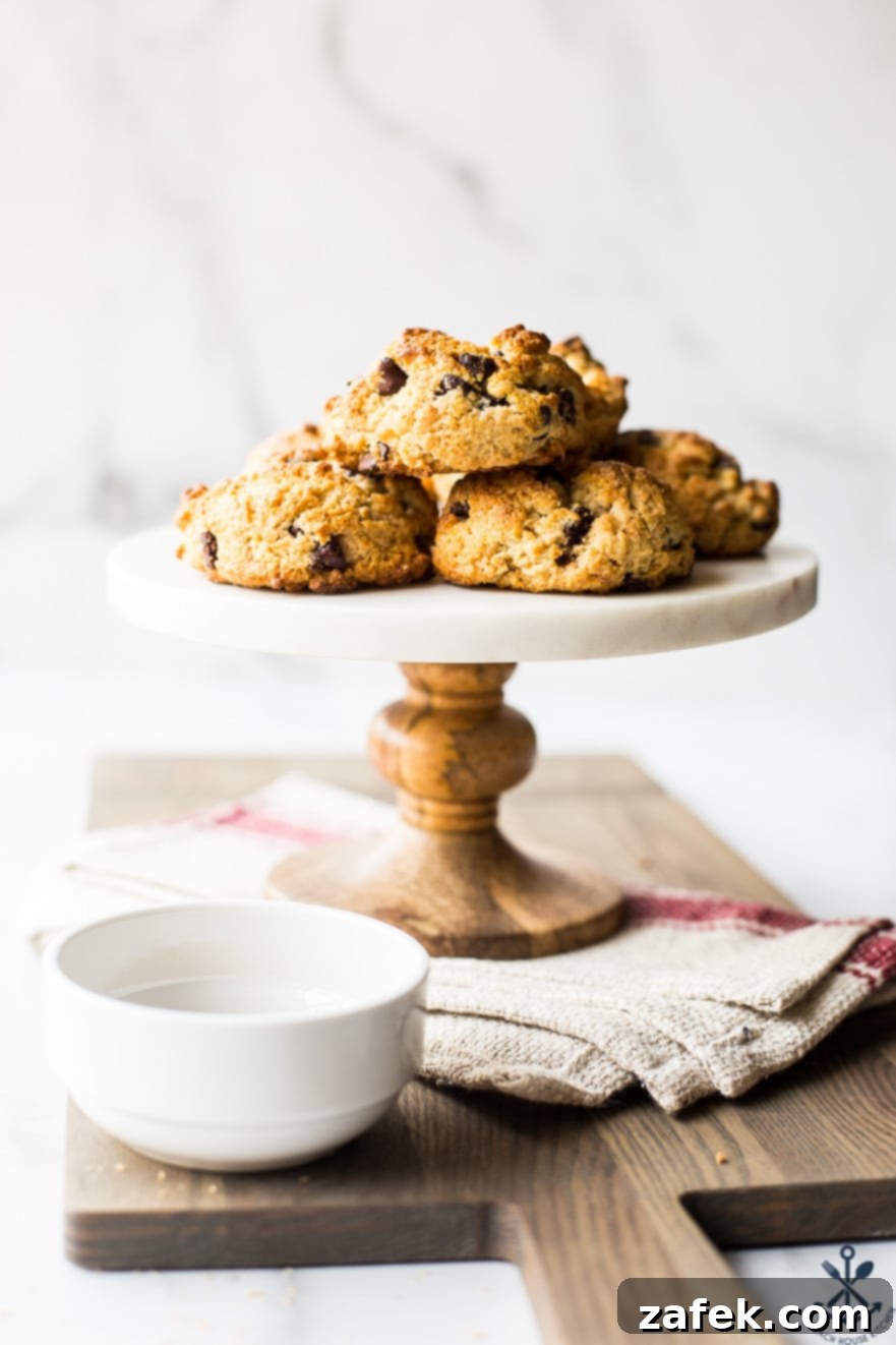 Golden Toasted Coconut Chocolate Chip Scones 9 Freshly baked chocolate chip toasted coconut scones stacked on a cake stand, ready to be served
