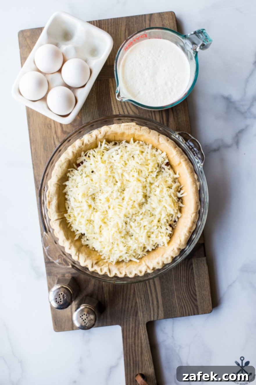 A close-up of a Quiche Lorraine slice, highlighting the melted Gruyère and creamy custard