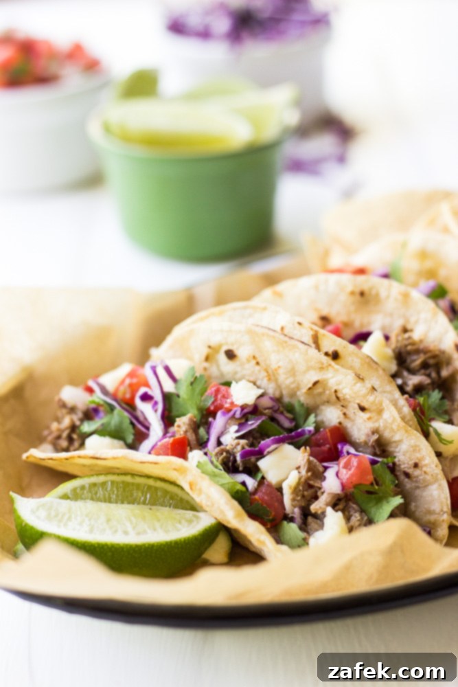 Crispy Pork Carnitas Tacos - Golden brown, tender pork piled high in warm tortillas with fresh toppings.
