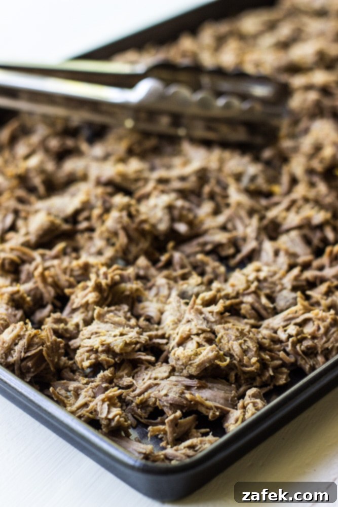 An assembled Crispy Pork Carnitas Taco with a blurred background, emphasizing the fresh ingredients.