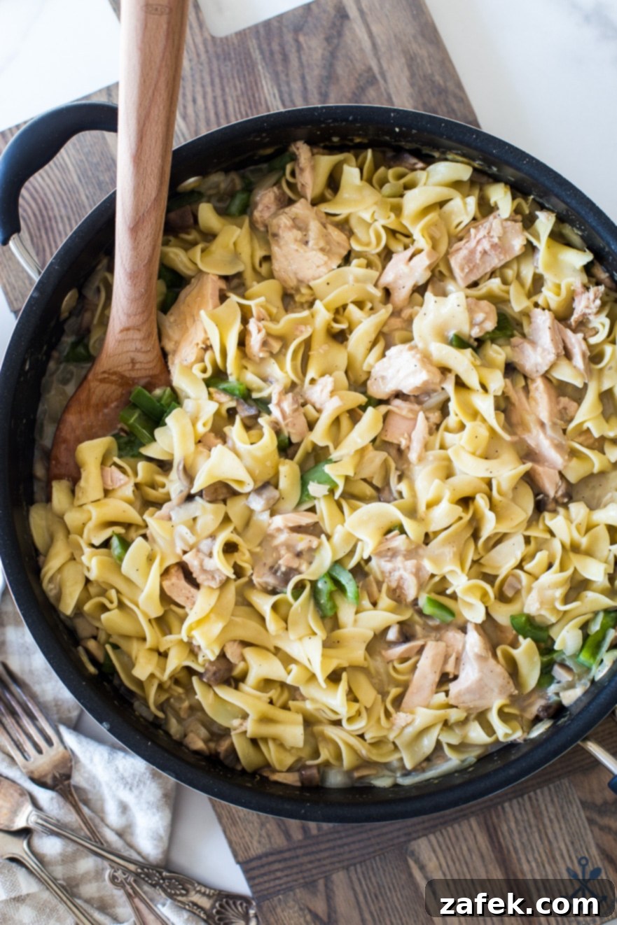 Creamy Tuna Noodle Delight 3 Close-up shot of a serving of tuna noodle casserole in a white bowl, showing creamy noodles and tuna.