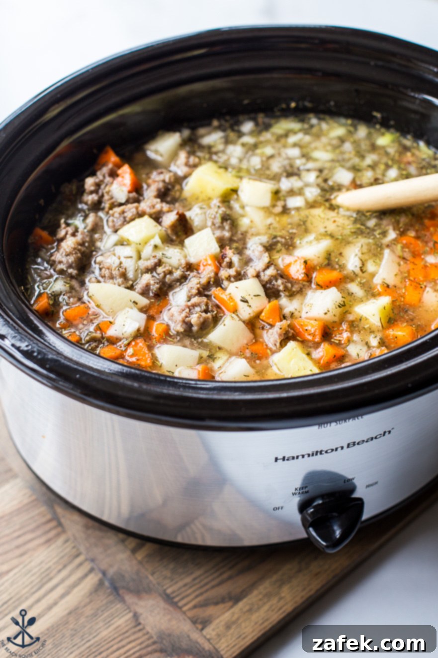 Bratwurst Potato Soup simmering in a slow cooker, showcasing its rich texture and ingredients