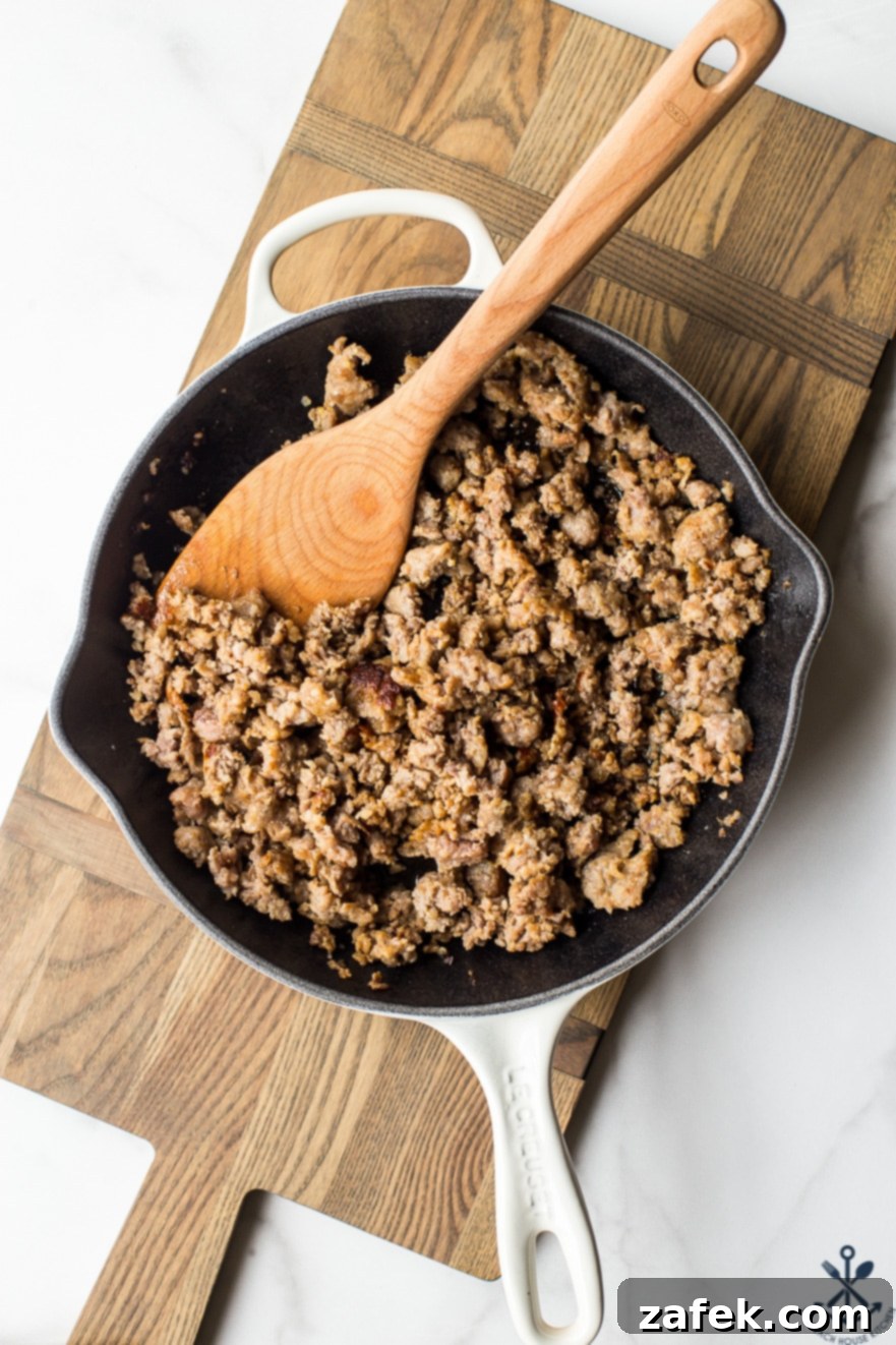 Overhead photo of cooked, crumbled bratwurst sausage in a skillet, perfectly browned
