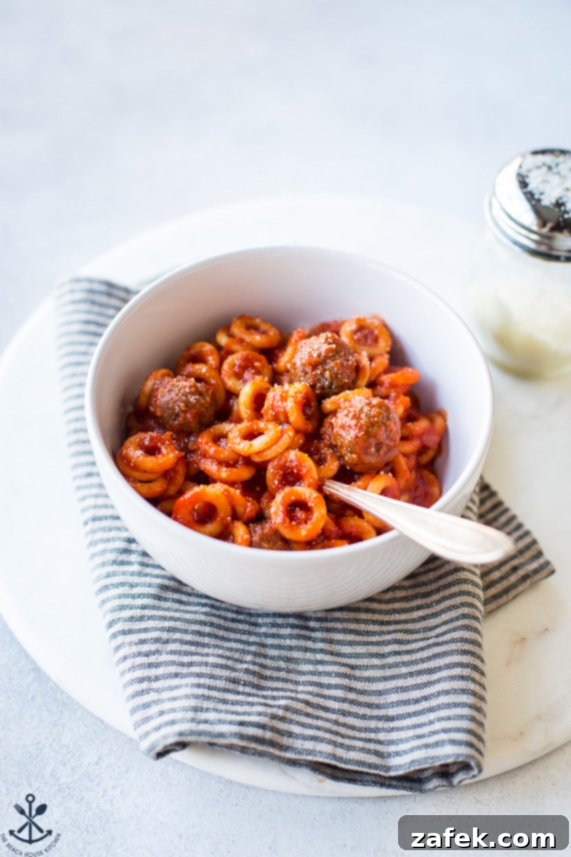 Up close photo of a bowl of homemade SpaghettiO's, highlighting the pasta rings and meatballs
