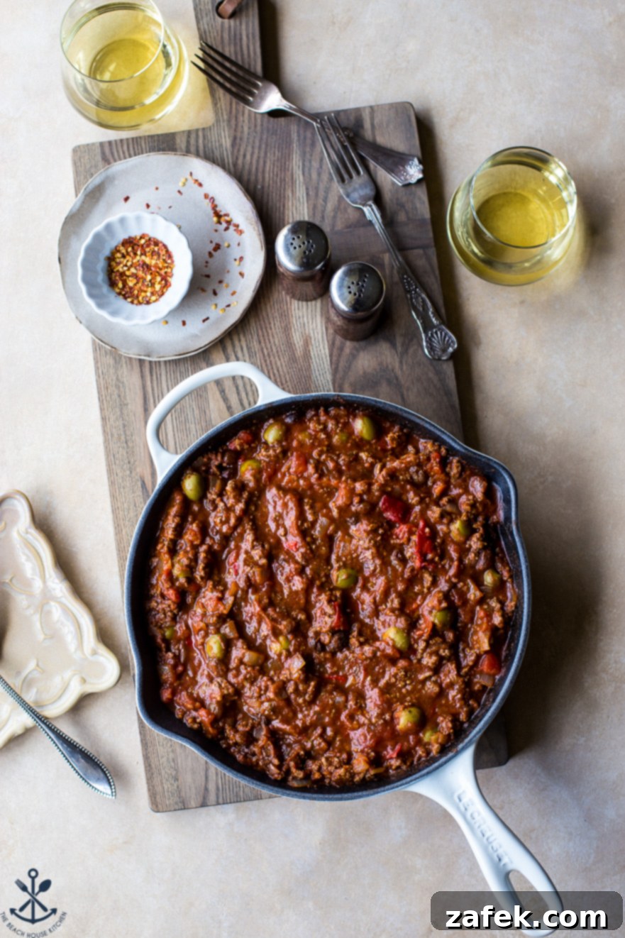 Overhead photo of skillet filled with Cuban Beef Picadillo, garnished and ready to serve