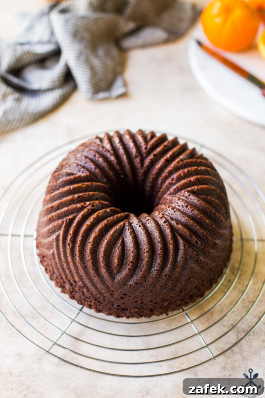 Zesty Chocolate Orange Bundt 3 A perfectly baked Chocolate Orange Bundt Cake cooling on a round silver wire rack.