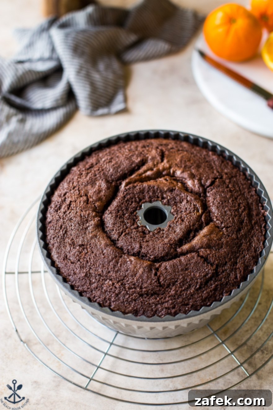 Zesty Chocolate Orange Bundt 7 A freshly baked chocolate orange bundt cake still in its pan, cooling on a wire rack.