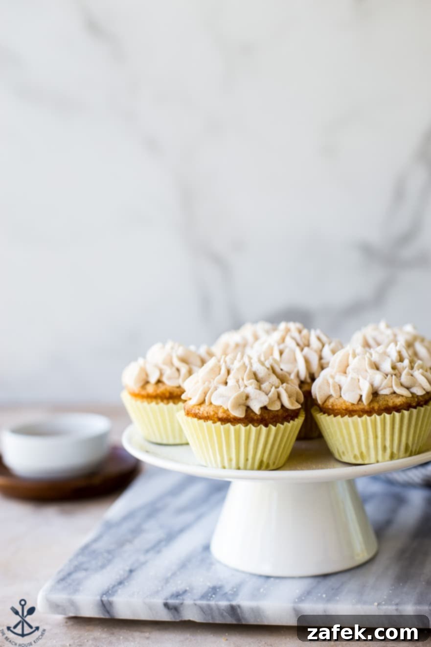 Spiced Snickerdoodle Cupcakes with Cinnamon Buttercream 3 Snickerdoodle Cupcakes with Cinnamon Buttercream beautifully arranged on a white cake stand, set against a marble background