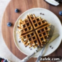 Ultimate Chocolate Chip Banana Bread Waffles 11 Overhead photo of chocolate chip banana bread waffles on a plate on a wooden board
