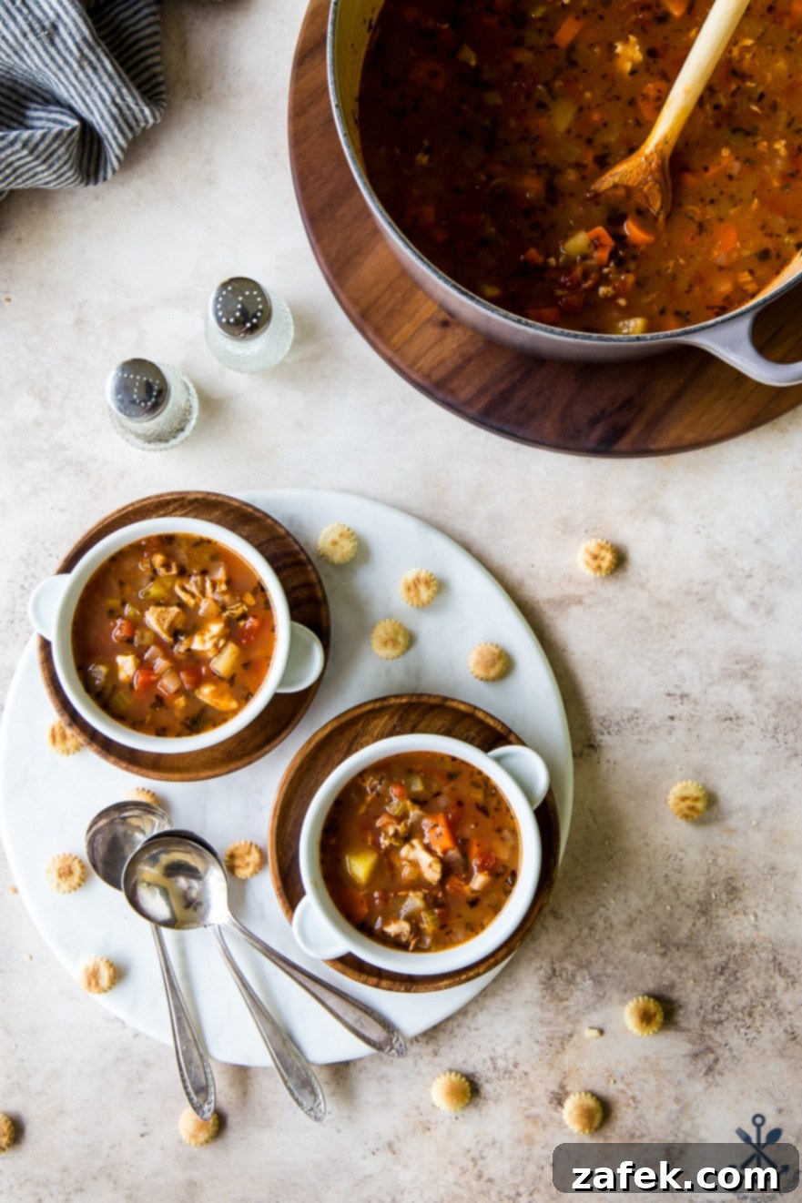 Manhattan's Red Clam Chowder 5 Detailed shot of the vibrant Manhattan Clam Chowder, showing the texture of clams, potatoes, and other vegetables.