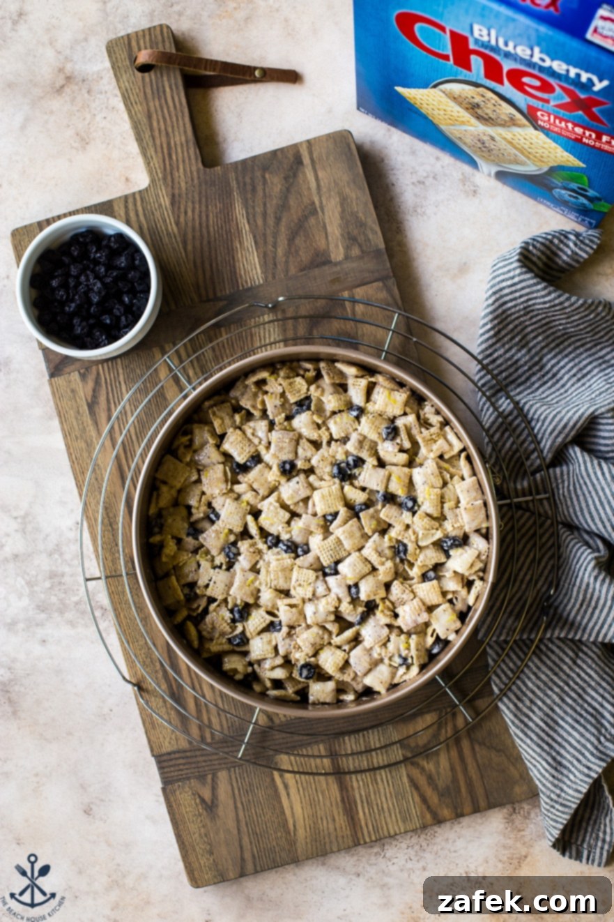 Blueberry Chex Crunch Bars 3 Close-up overhead view of Blueberry Chex Krispie Treats set in a silver springform pan on a rustic wooden board, ready to be chilled and sliced.