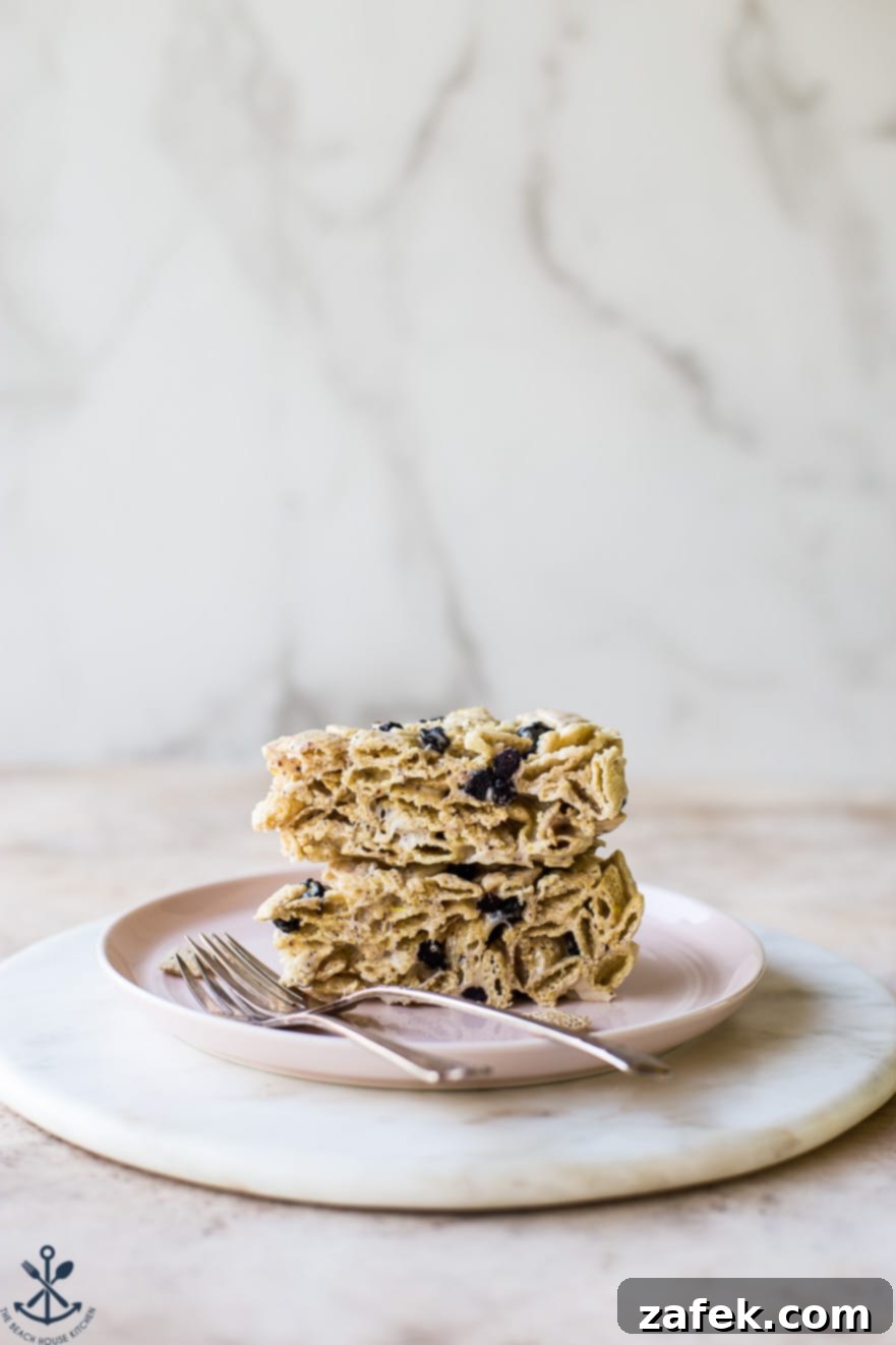 Blueberry Chex Crunch Bars 4 Two generous servings of Blueberry Chex Krispie Treats presented on a charming pink plate, accompanied by two forks, ready for sharing.