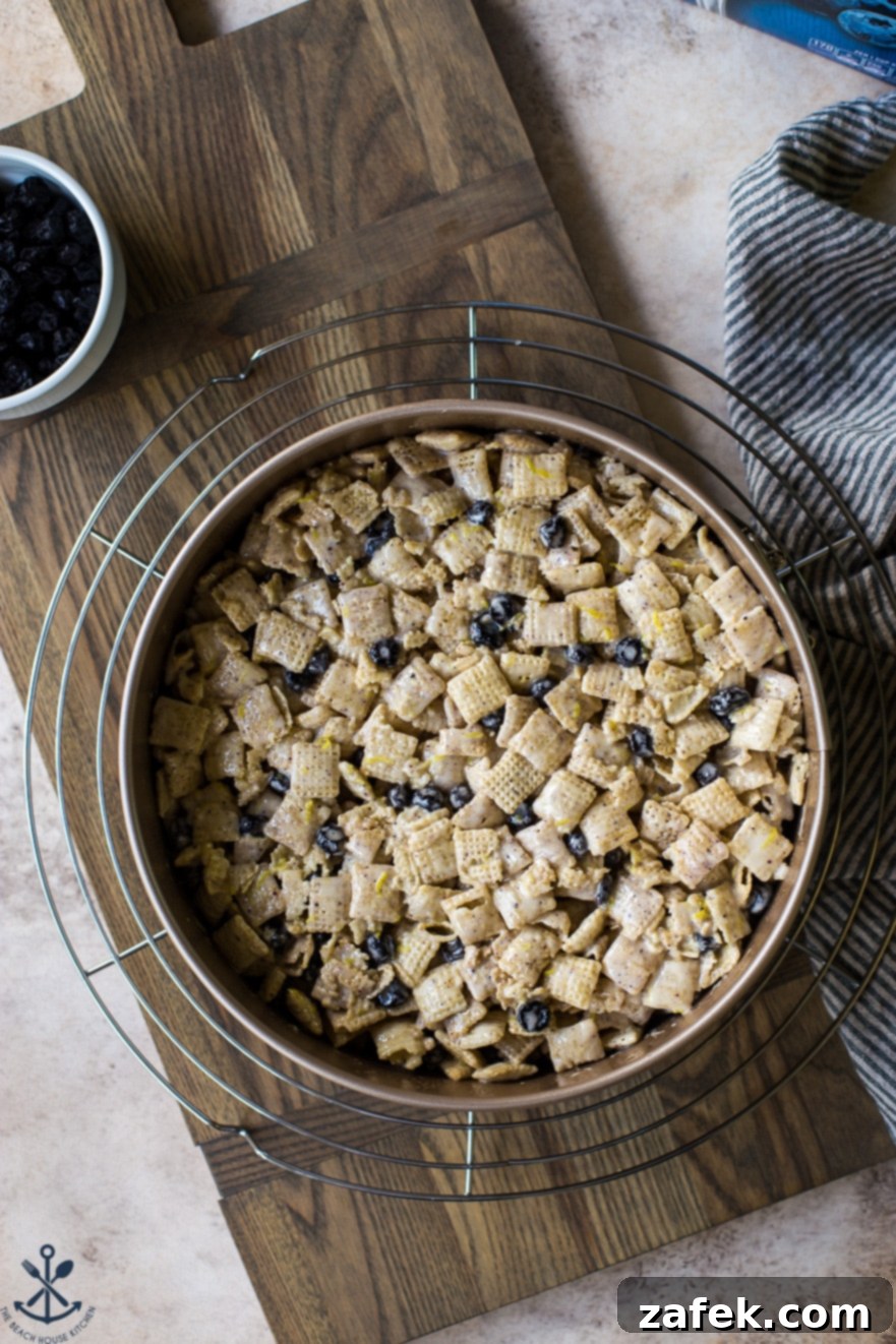 Blueberry Chex Crunch Bars 6 Blueberry Chex Krispie Treats cooling in a silver springform pan on a light wooden board, demonstrating the easy process of this no-bake recipe.