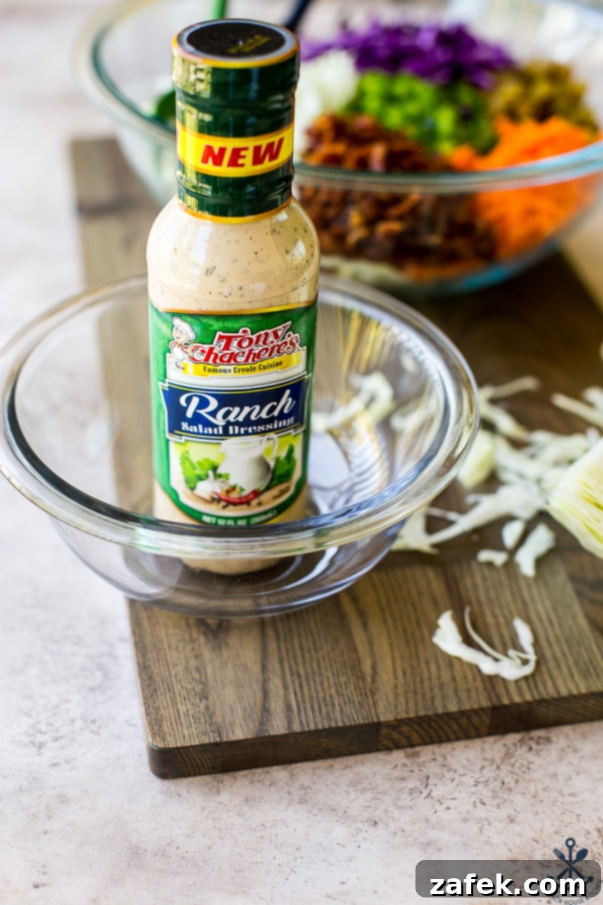 A bottle of Tony Chachere's Ranch Dressing in a glass bowl on a wooden board