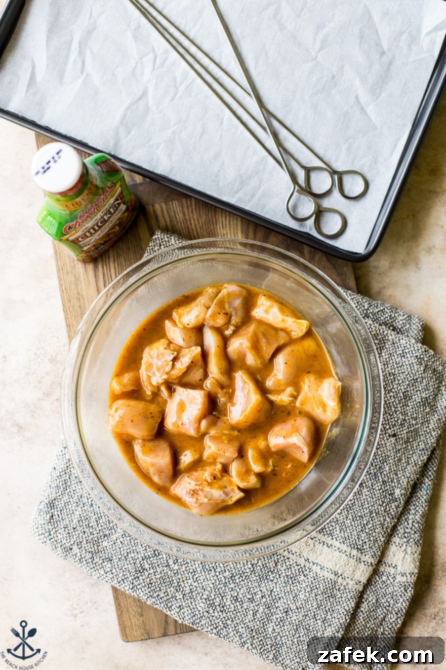 Overhead photo of uncooked chicken pieces marinating in a glass bowl
