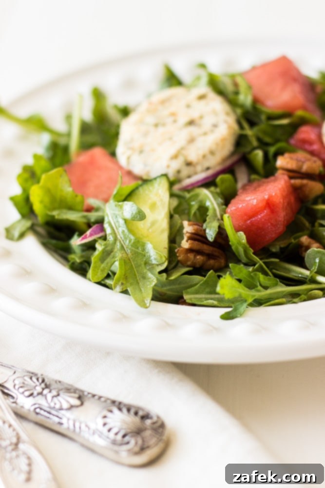 Close-up of Watermelon Salad with Arugula & Baked Goat Cheese, showcasing texture