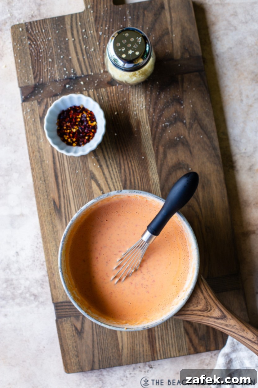 Overhead photo of a saucepan of roasted red pepper alfredo sauce