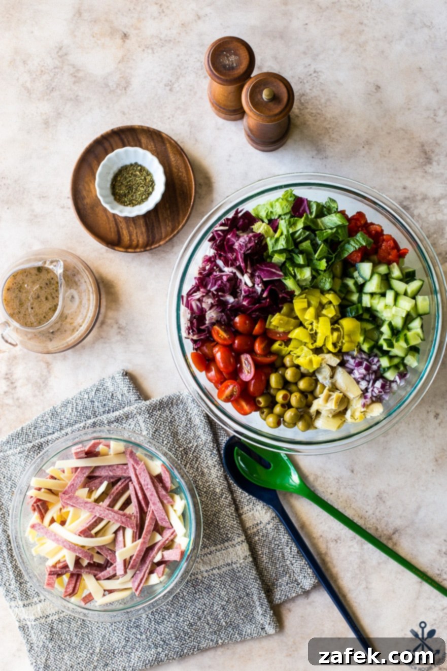 Ingredients for Italian Chopped Salad including fresh vegetables, salami, and cheese, on a cutting board