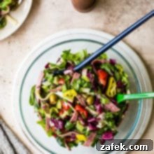 Italian Chopped Salad in a glass bowl on a round white marble board