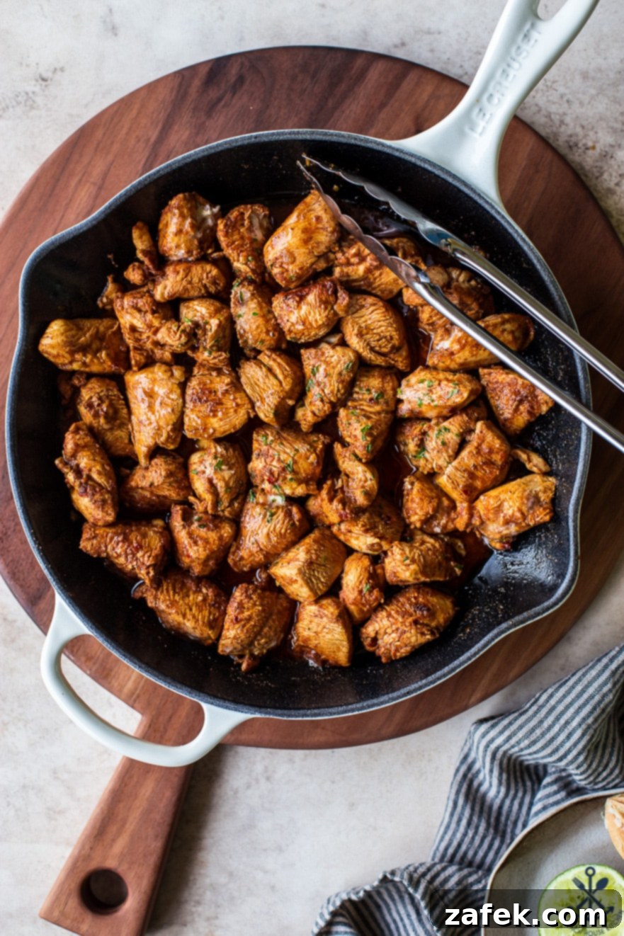 Fiesta Chicken Poppers 4 A serving of Mexican spiced chicken bites on a plate with fresh cilantro and lime wedges, emphasizing its deliciousness