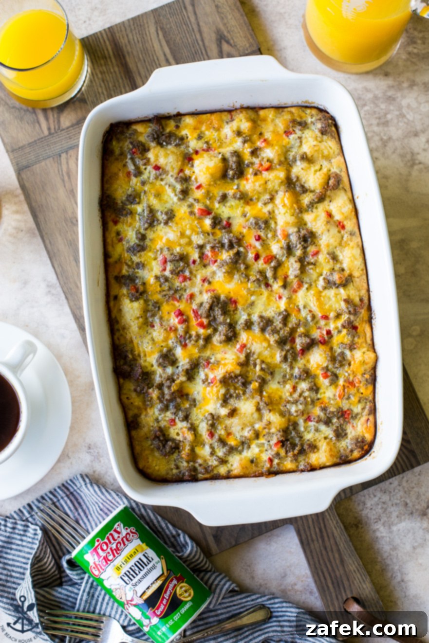 Creole Breakfast Casserole 2 Overhead photo of Creole Breakfast Egg Bake with Sausage and Potatoes in a white baking dish on a wooden board