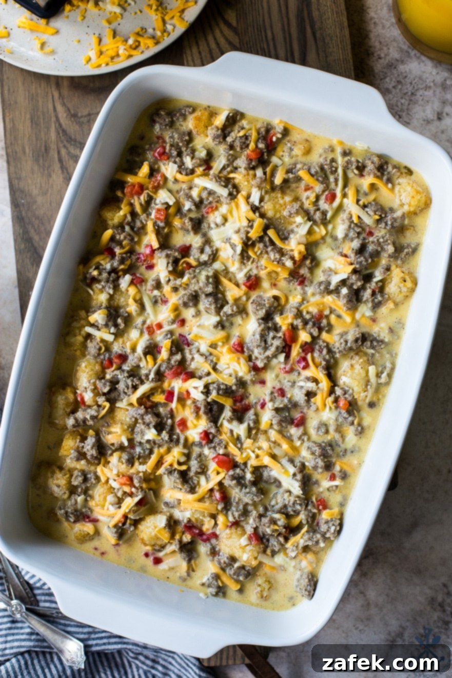Creole Breakfast Casserole 5 Up close photo of pre baked Creole Breakfast Egg Bake with Sausage and Potatoes in white baking dish