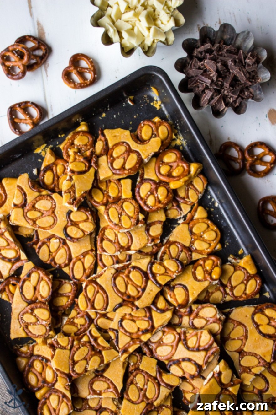 Overhead photo of a freshly made batch of pretzel toffee cooling on a baking sheet, showcasing its golden hue and pretzel base.