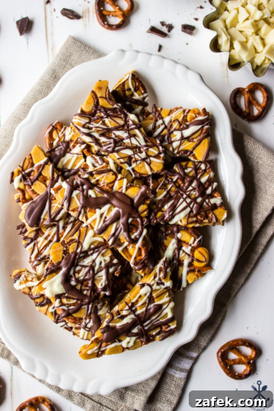 Overhead photo of individual pieces of pretzel toffee on a pristine white oval plate, ready for serving.