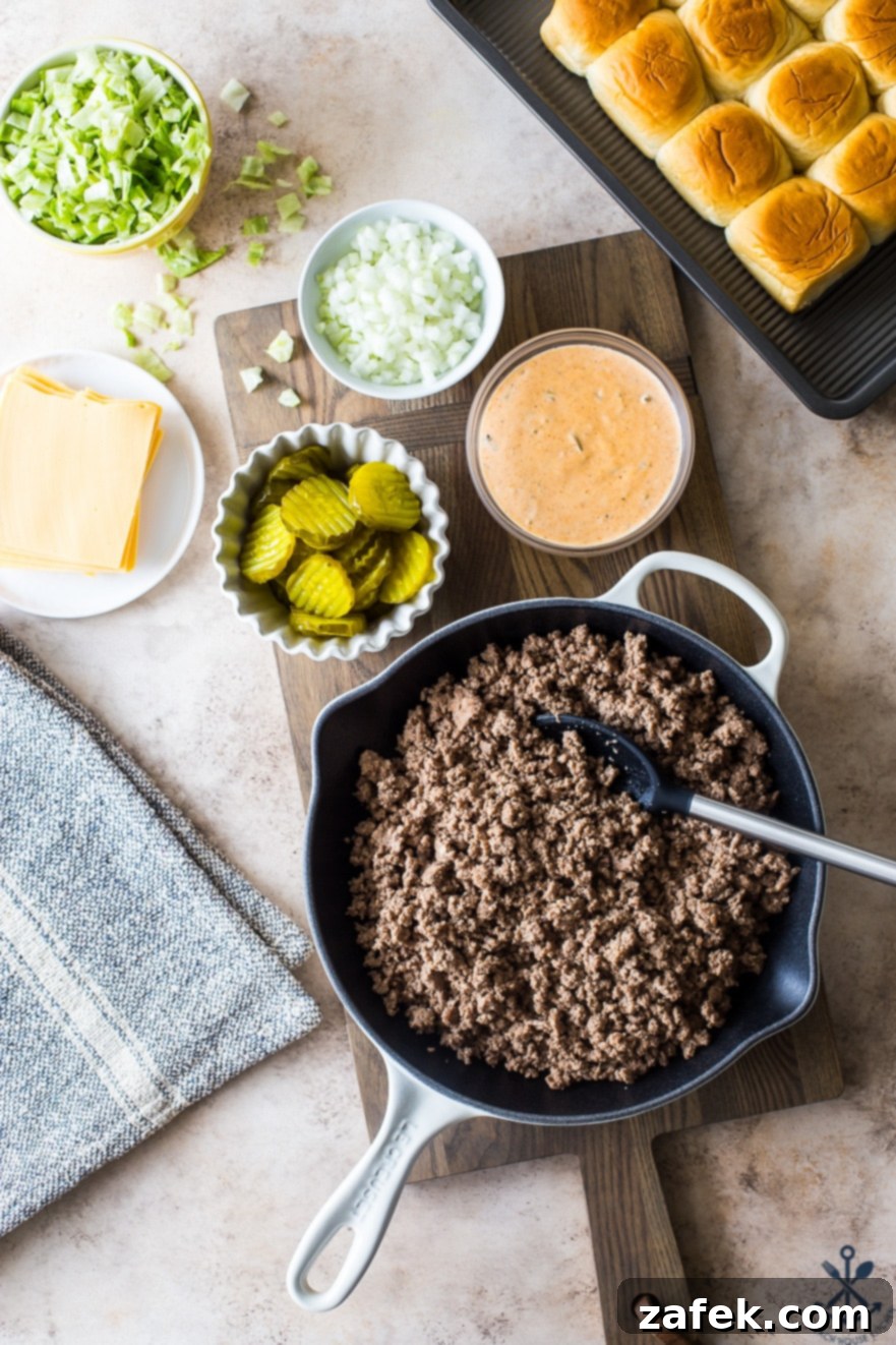 Overhead view of all the ingredients laid out for Tony's Baked Cheeseburger Sliders, including buns, cheese, beef, and special sauce
