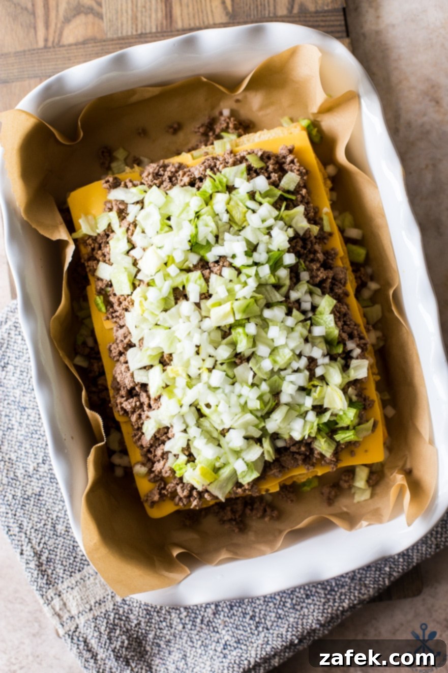 A closer look at the pre-cooked layers of Tony's Baked Cheeseburger Sliders, showing the beef, cheese, and toppings before baking