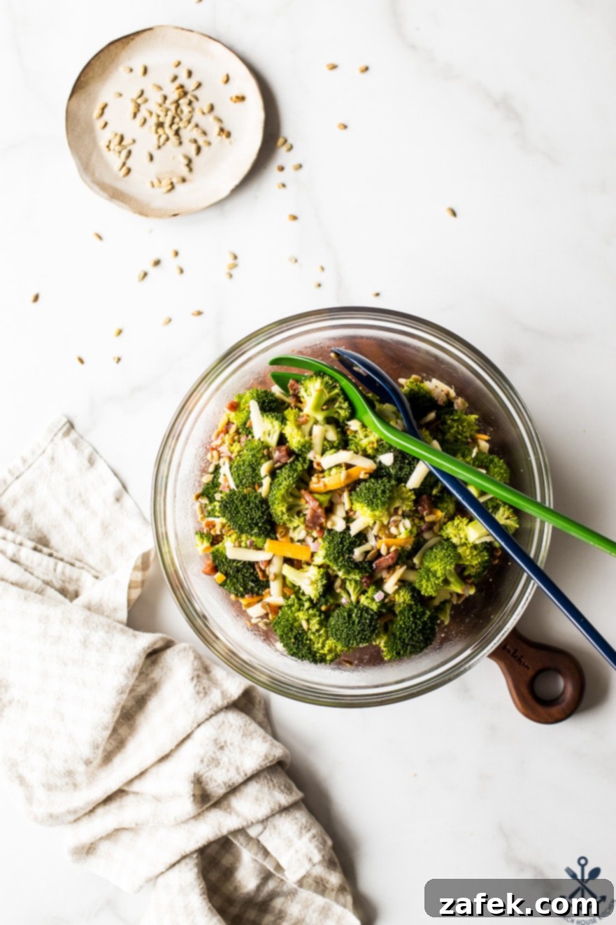 Close-up overhead photo of Classic Broccoli Salad with Bacon in a glass bowl, highlighting textures