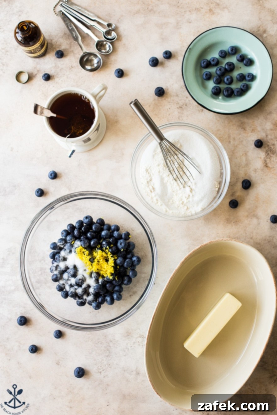 Overhead photo showcasing all the fresh, high-quality ingredients neatly arranged for making Earl Grey blueberry cobbler on a kitchen counter