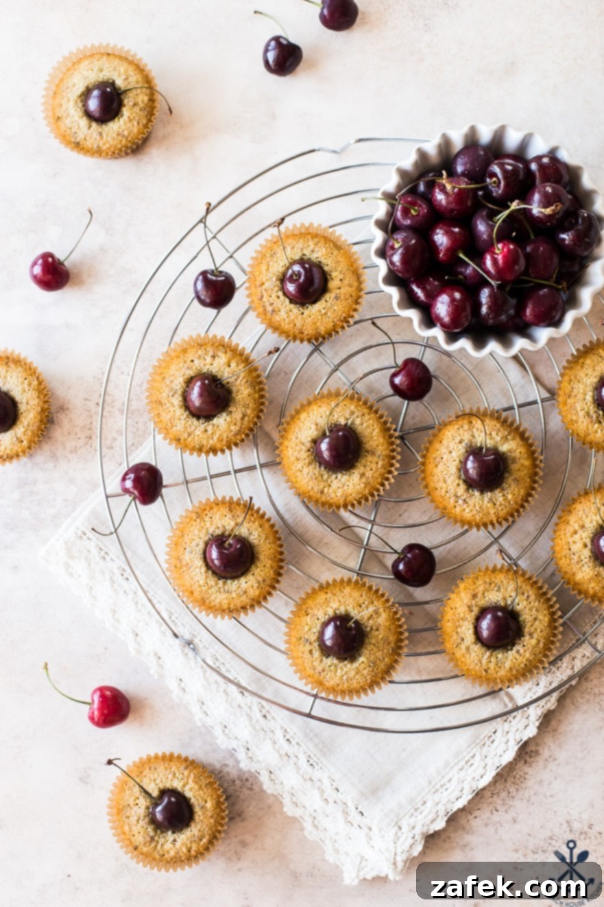 Dainty Cherry Pistachio Tea Cakes 2 Delicious Sweet Cherry Pistachio Tea Cakes cooling on a round wire rack, showcasing the golden-brown crust and vibrant cherry topping.