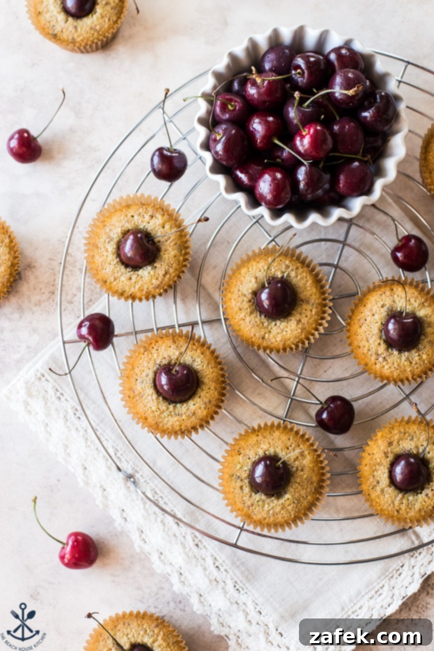 Dainty Cherry Pistachio Tea Cakes 6 An overhead shot of multiple Sweet Cherry Pistachio Tea Cakes arranged on a wire cooling rack, ready for serving.