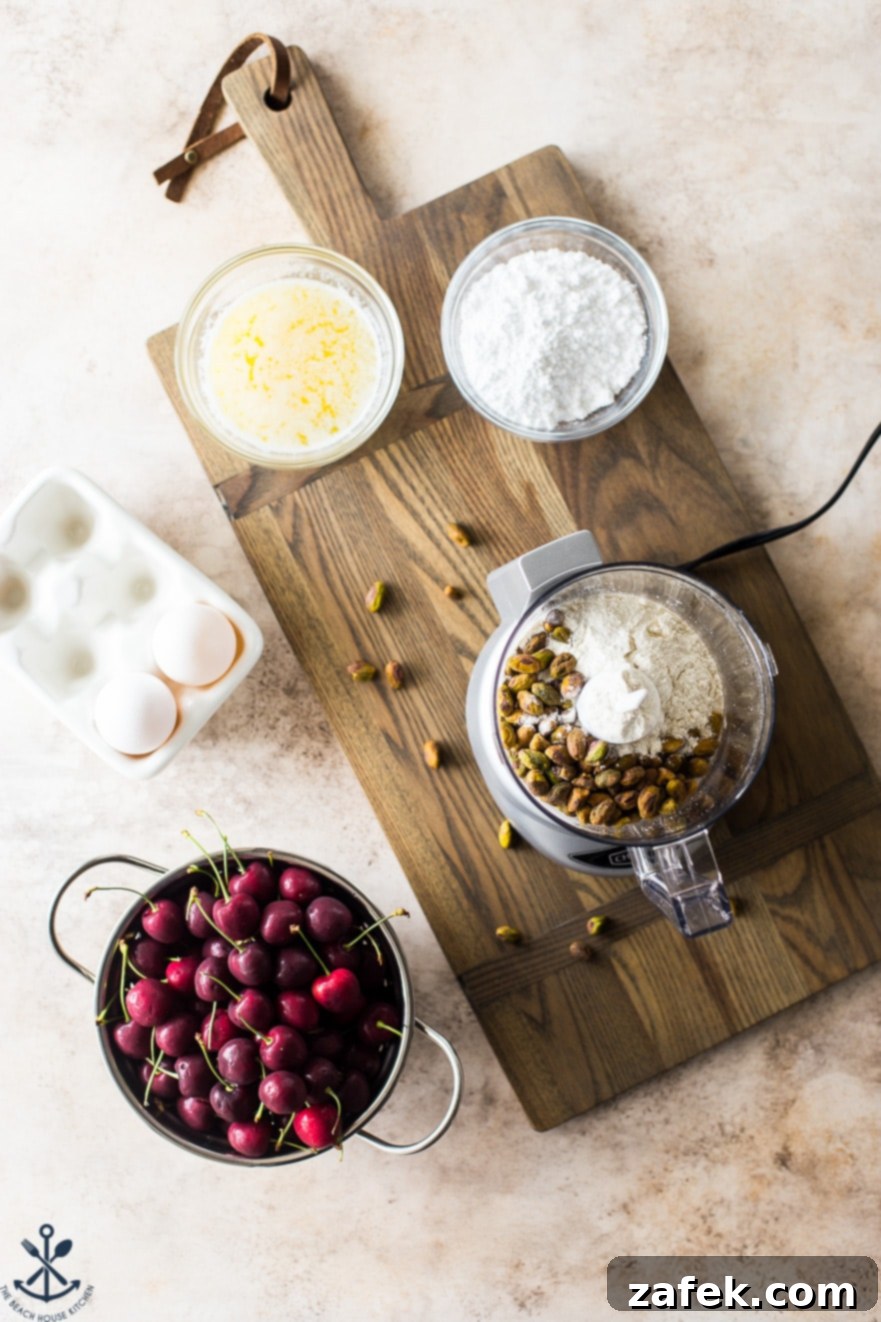 Dainty Cherry Pistachio Tea Cakes 7 An inviting overhead display of all the fresh ingredients needed for Sweet Cherry Pistachio Tea Cakes, arranged artfully on a wooden board.