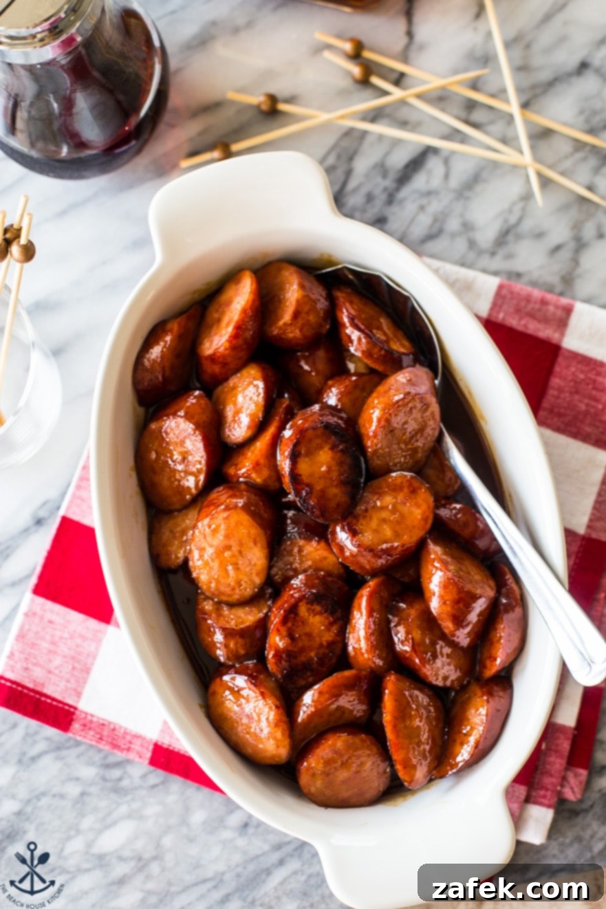 Maple Bourbon Glazed Kielbasa Bites 3 Overhead photo of maple bourbon BBQ kielbasa bites in a pristine white oval dish, ready to be served.