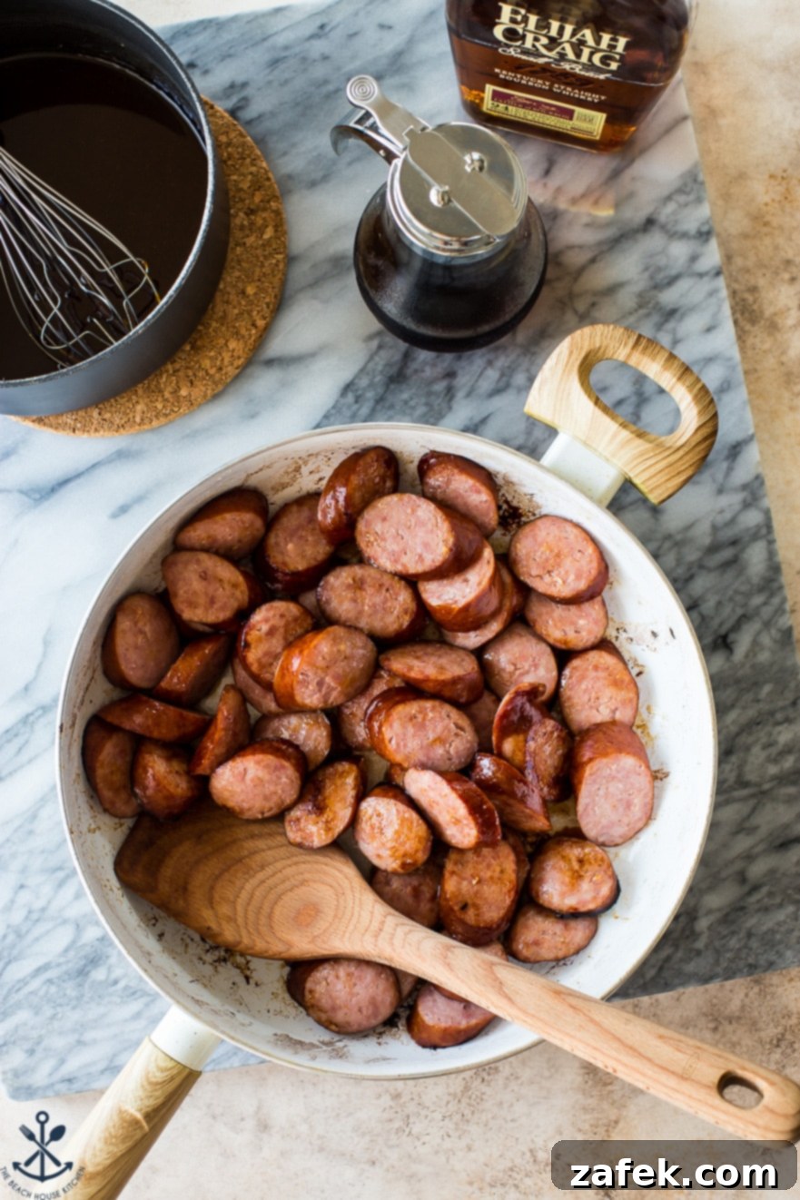 Maple Bourbon Glazed Kielbasa Bites 4 Overhead photo of a skillet filled with freshly sliced kielbasa, browning beautifully.