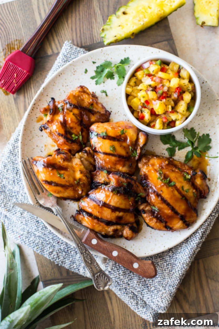 Tropical Huli Huli Chicken with Zesty Pineapple Salsa 3 Overhead photo of beautifully grilled Huli Huli Chicken pieces served alongside a bowl of colorful pineapple salsa.