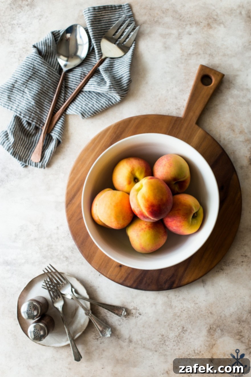 A charming white bowl brimming with perfectly ripe, golden peaches resting on a round wooden board