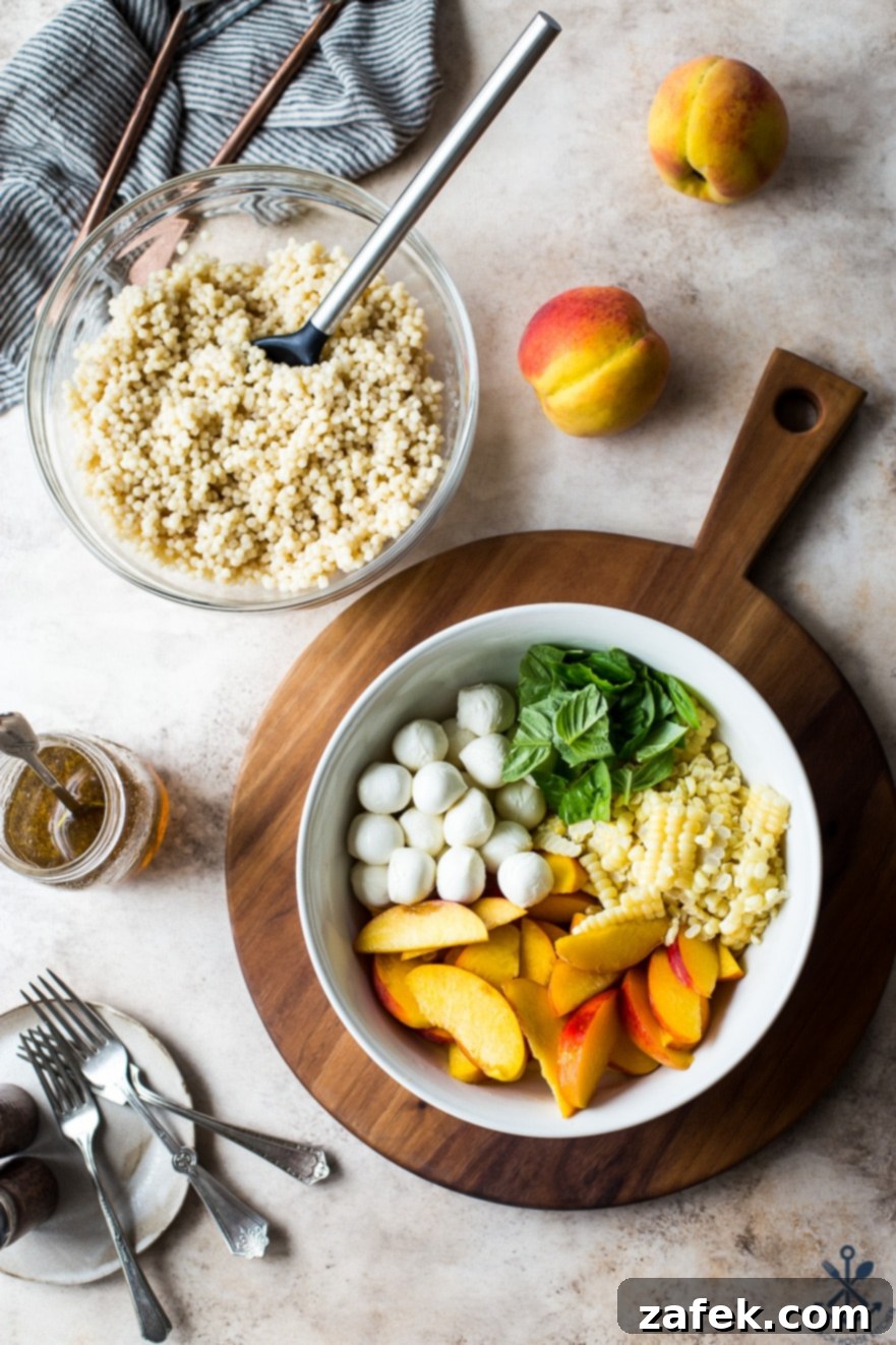 Overhead shot of all fresh ingredients for Peach Corn Caprese Couscous Salad laid out in two bowls on a wooden surface