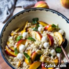 Peach Corn Caprese Couscous Salad in a bowl on a wooden board